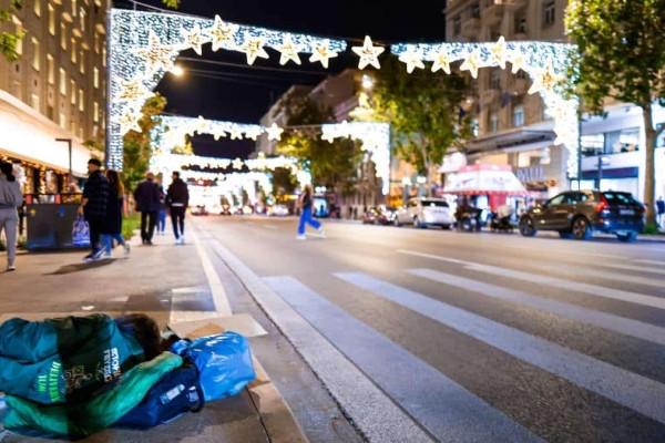 Η φωτογραφία της ημέρας: Άστεγοι στη στολισμένη για τα Χριστούγεννα Αθήνα