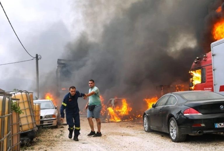 Φωτιά στην Αττική: Πυροσβέστης «παίρνει σηκωτό» ιδιοκτήτη μάντρας αυτοκινήτων που τυλίγεται στις φλόγες