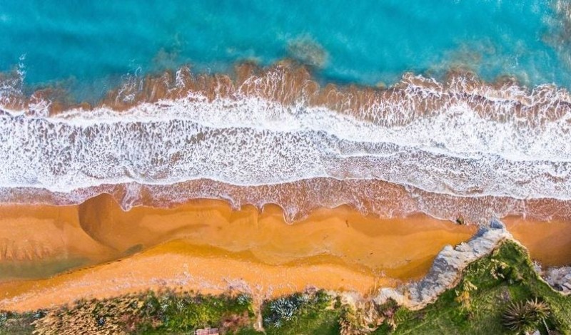 Κατακόκκινη άμμος και κρυστάλλινα γαλανά νερά: Η παραλία ελληνικού νησιού που βρίσκεται στις 20 πιο παράξενες του κόσμου