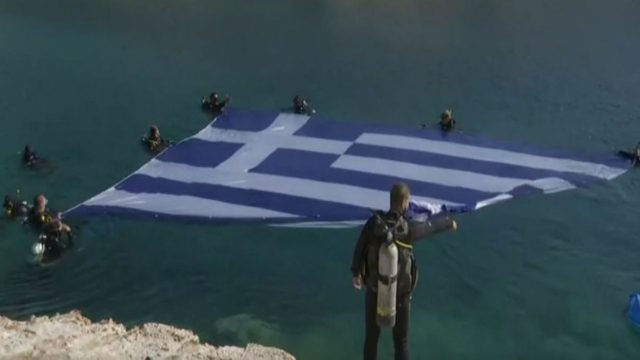 Εντυπωσιακό βίντεο: Στη Βουλιαγμένη καταδύθηκε η μεγαλύτερη ελληνική σημαία