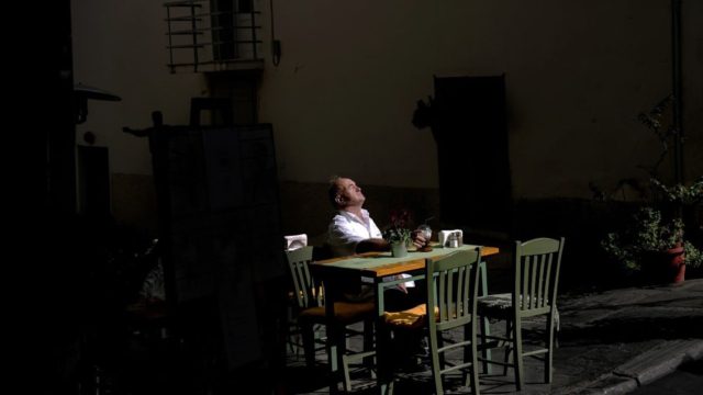 Η φωτογραφία της ημέρας: Σερβιτόρος στην Πλάκα απολαμβάνει τον πρωινό ήλιο πριν τη δουλειά