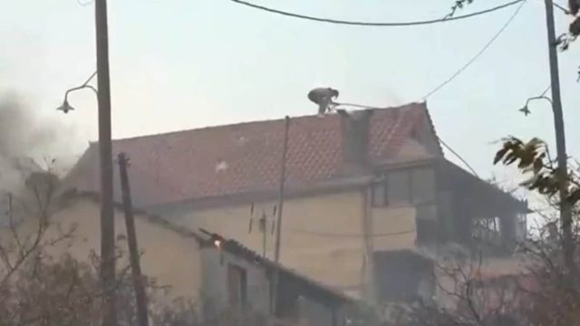 Καίγονται σπίτια στη Χασιά – Πολίτης σκαρφαλωμένος στα κεραμίδια προσπαθούσε με μάνικα να σώσει το δικό του