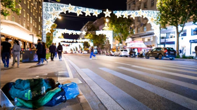 Η φωτογραφία της ημέρας: Άστεγοι στη στολισμένη για τα Χριστούγεννα Αθήνα