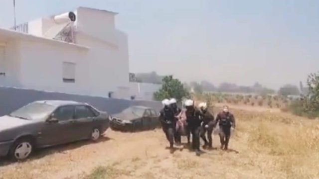 Πυρκαγιά στην Κερατέα: Αστυνομικοί παίρνουν σηκωτή γυναίκα και απομακρύνουν φιάλες υγραερίου από σπίτι που έχει πάρει φωτιά