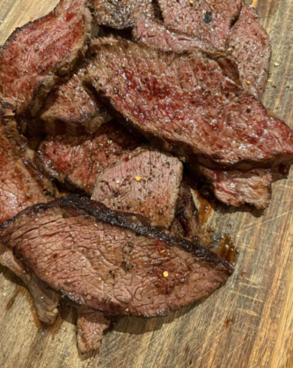 Λεπτοκομμένες φέτες Picanha Black Angus ψημένες medium-rare δίπλα σε μια τραγανή φωλιά από πατάτες τηγανητές