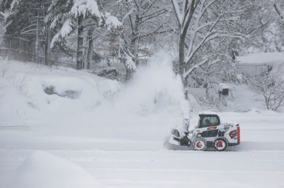 Ένα εκχιονιστικό μηχάνημα προσπαθεί να καθαρίσει μια λεωφόρο της Νέας Υόρκης εν μέσω σφοδρής χιονόπτωσης και περιορισμένης ορατότητας