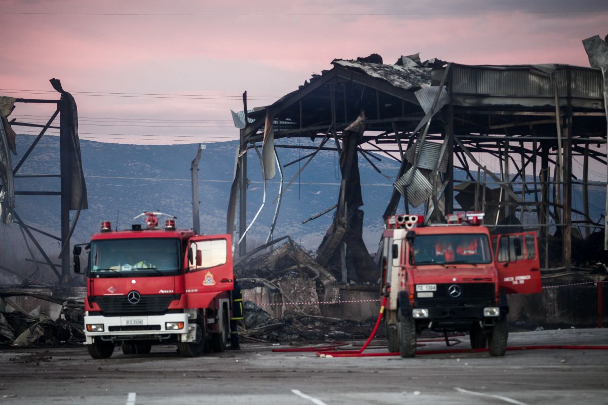 Εικόνα καταστροφής σε βιομηχανικό κτίριο με καπνούς και διαλυμένα μεταλλικά πάνελ μετά από ισχυρή έκρηξη