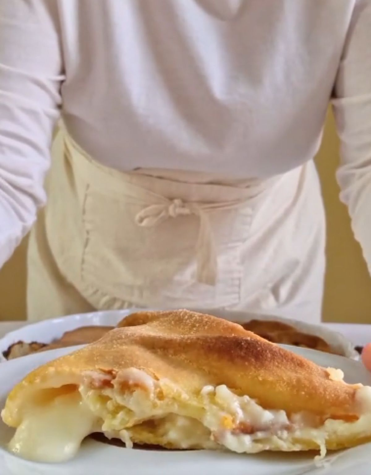 Κοντινό πλάνο ενός κομματιού τυρόπιτας που δείχνει την πλούσια λευκή γέμιση κρέμας και τα λεπτά στρώματα του χειροποίητου φύλλου