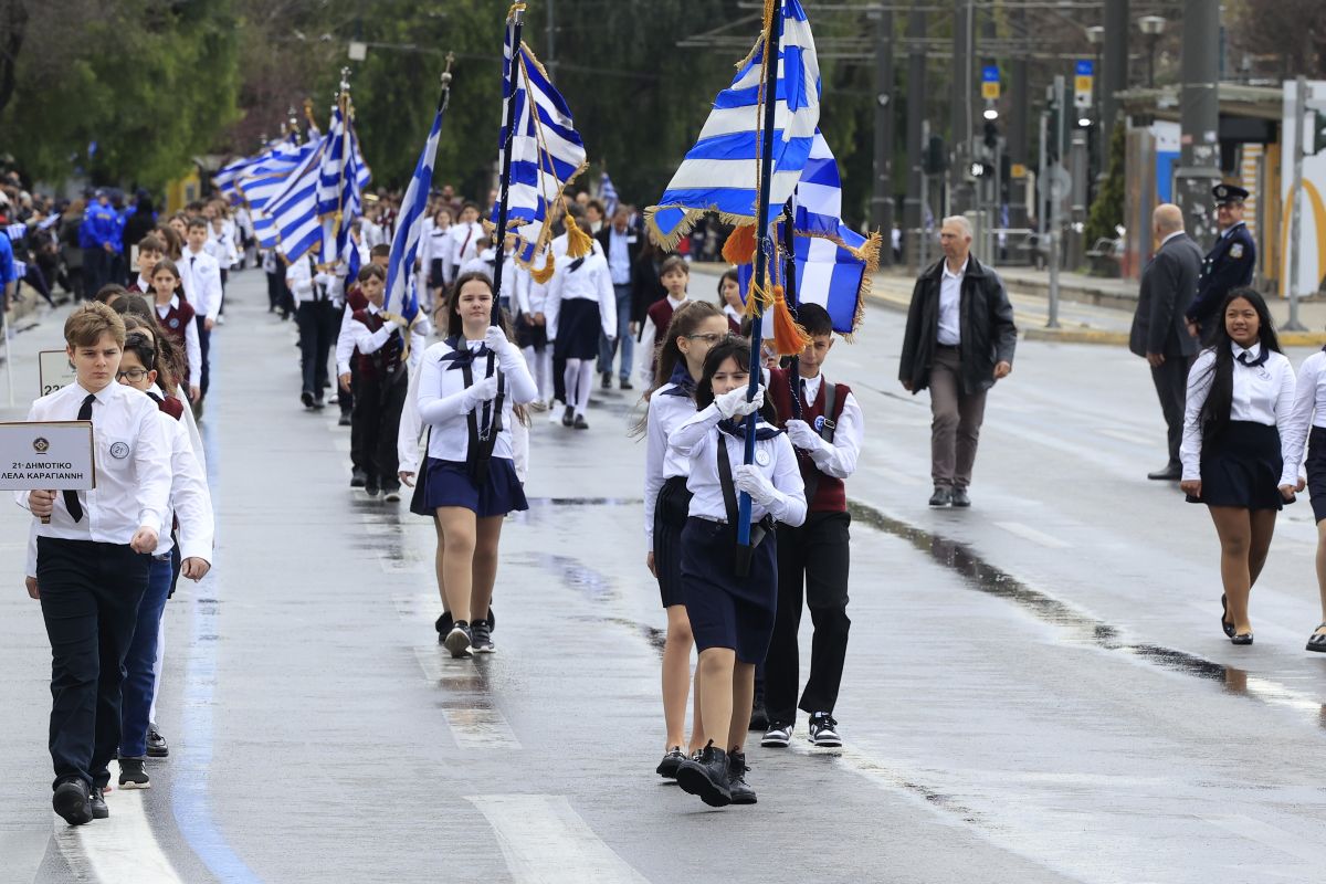Μαθητές παρελαύνουν μέσα στη βροχή