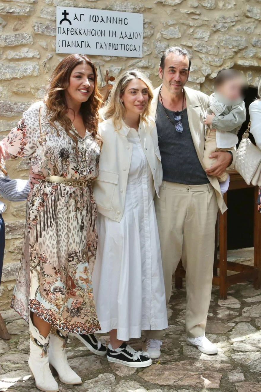 Ο Πάνος Μουζουράκης και η Μαριλού Κόζαρη κρατούν τον γιο τους μετά το τέλος του μυστηρίου στην εκκλησία, μαζί με την Έλενα Παπαρίζου που είναι η νονά του μικρού